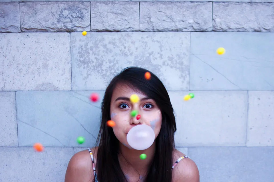 A girl blowing chew gum