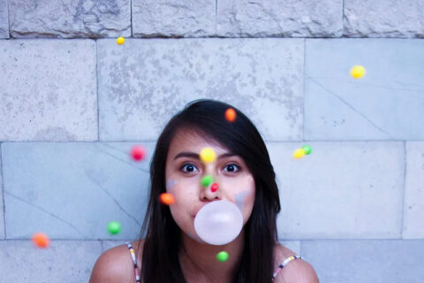 A girl blowing chew gum